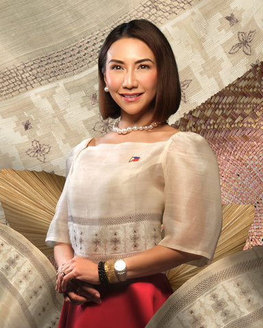 Department of Tourism Secretary Christina Frasco wears an elegant butterfly-sleeved organza top and Mikado silk skirt, accessorized with a white South Sea pearl necklace, white South Sea pearl studs, and a Philippine flag pin.