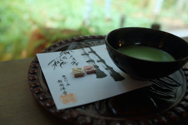 A cup of green tea on a hand-carved wooden plate