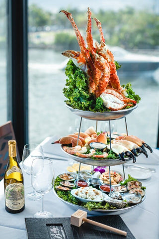 A Platter of Crab Sauces and Vegetables with a Bottle of Wine