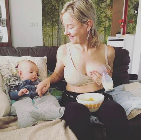 Mamá usando Recolector de silicona Haakaa para leche materna mientras juega con su bebé 