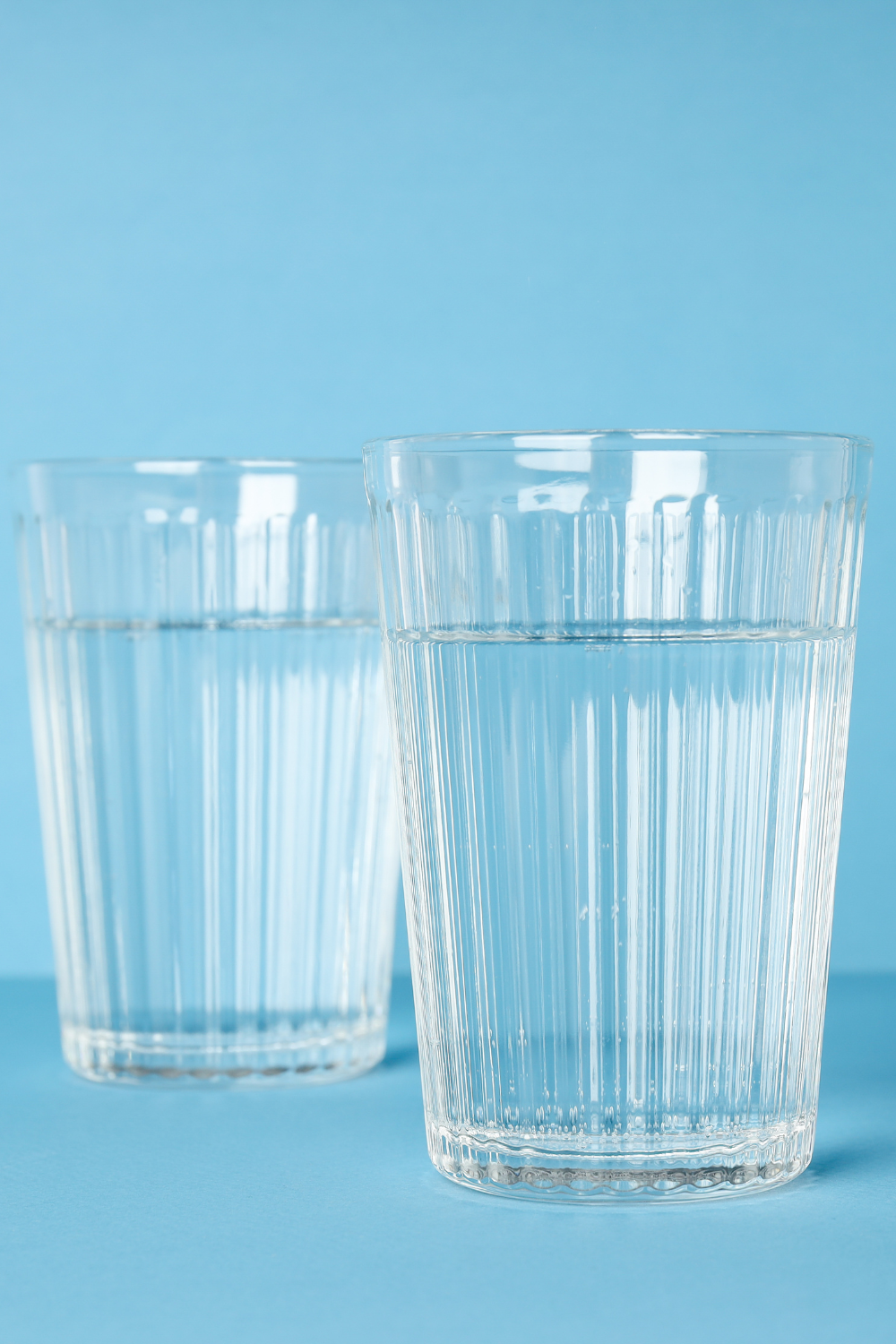 two glassed of water on a blue background