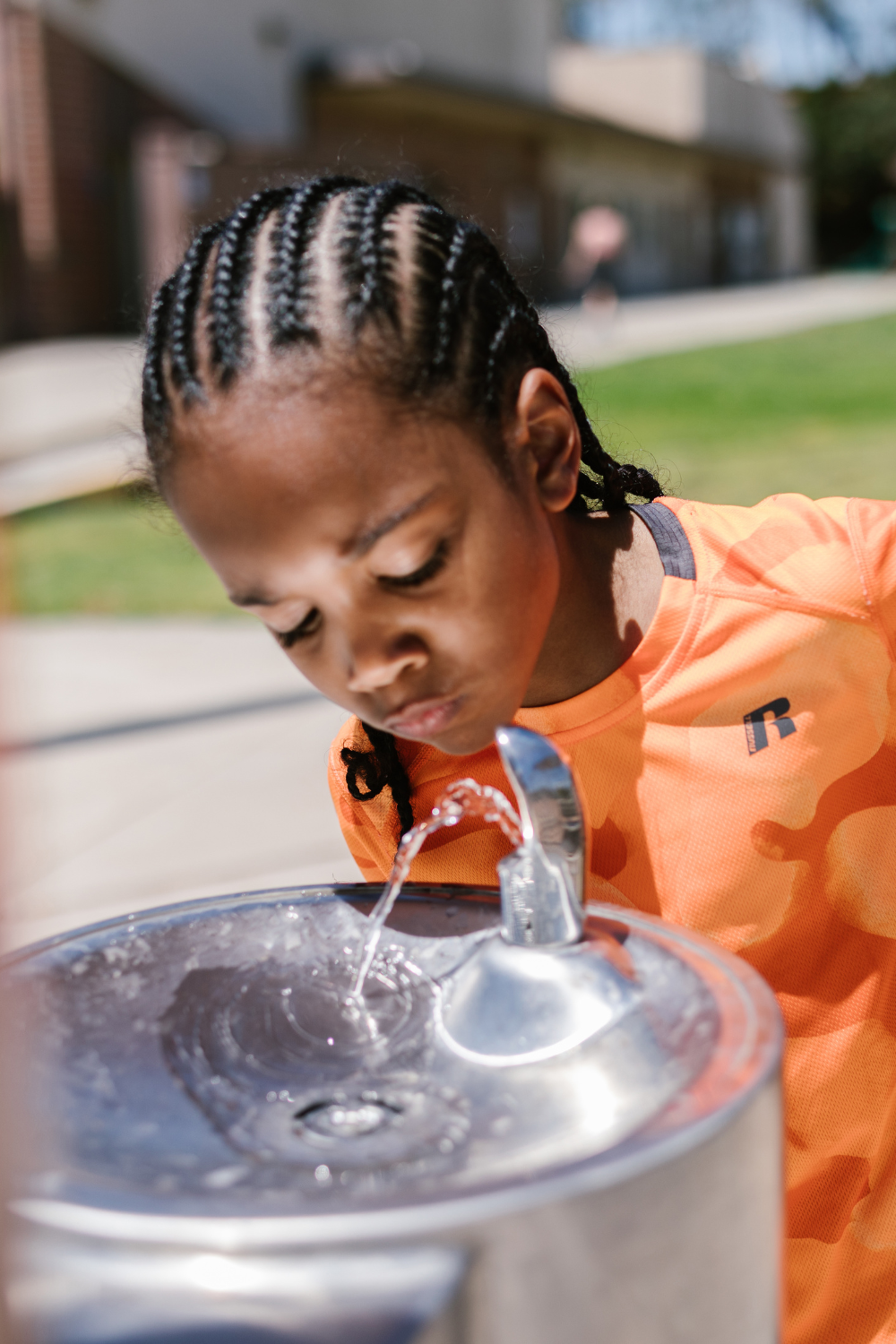 kid drinking from water fountain