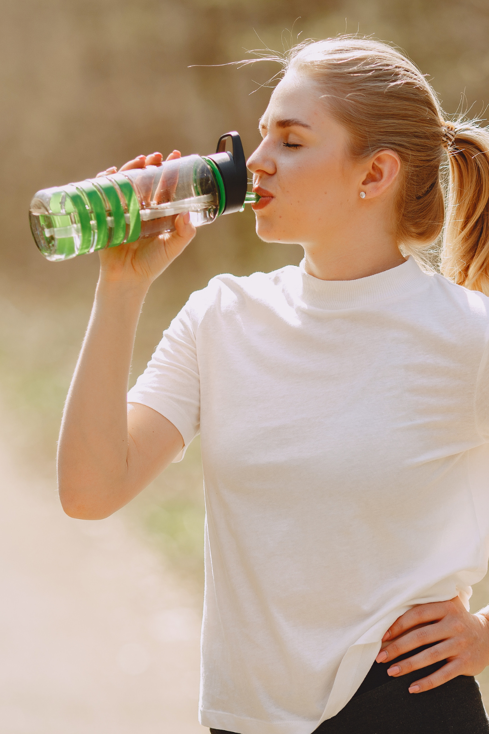 woman drinking from plastic water bottle