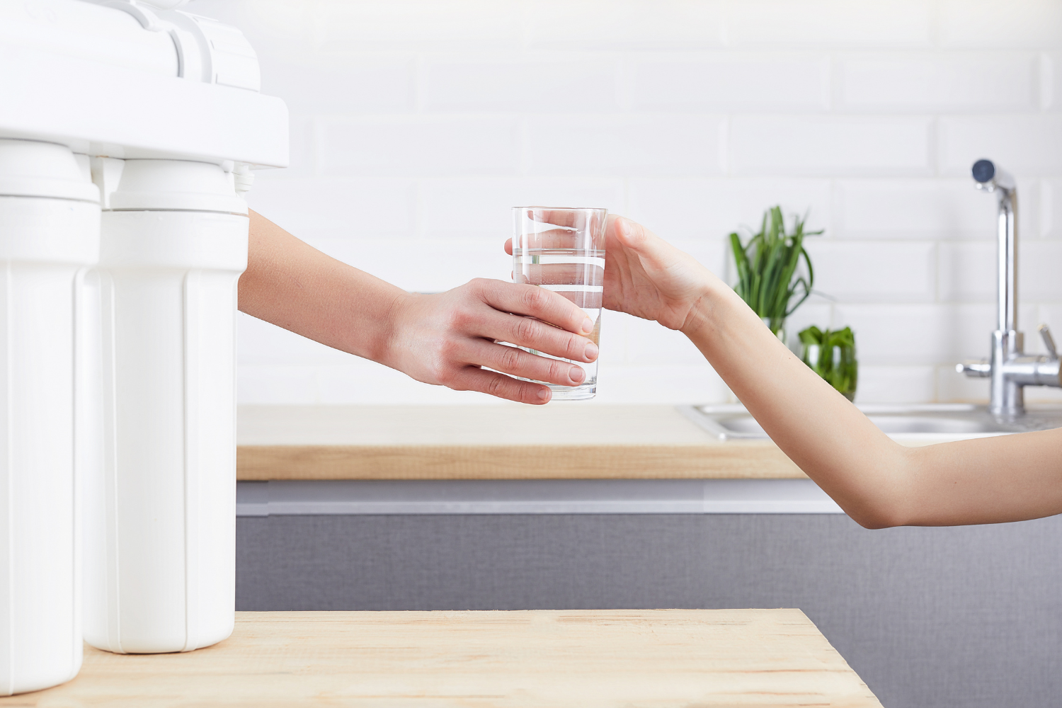 person grabbing glass of purified water