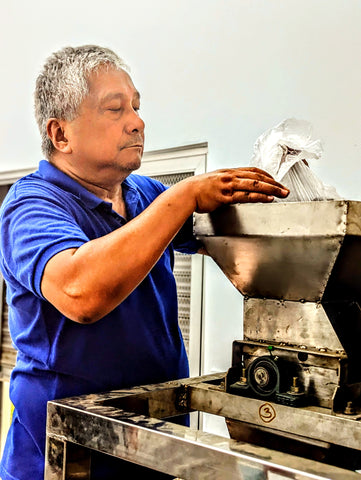 SICAP President Sir Floro filling the Winnower at the Chocolate Factory in the Philippines where indi chocolate volunteered to work with cacao farmers