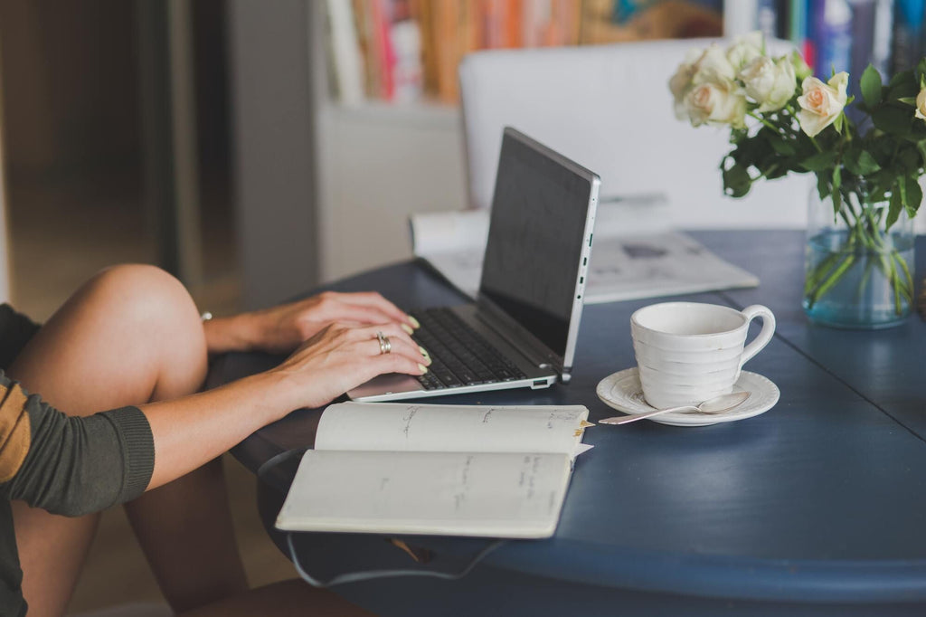 Woman working on a laptop with coffee