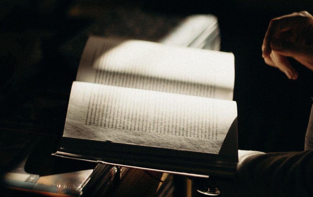 Person reading book in dim room