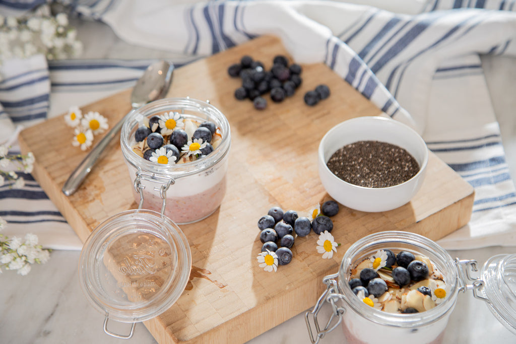 Food board with yogurt, blueberries and flowers