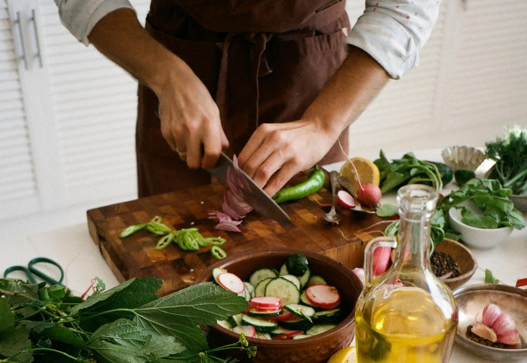 Person chopping fresh vegetables on cutting board