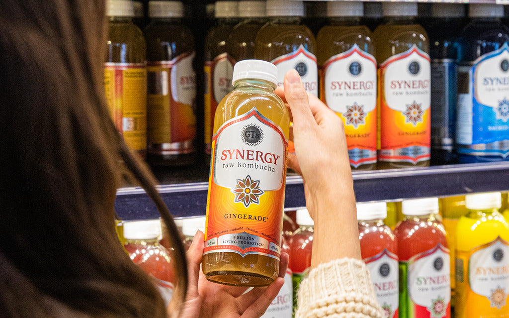 Woman shopping in-store for GT's SYNERGY Raw Kombucha Gingerade