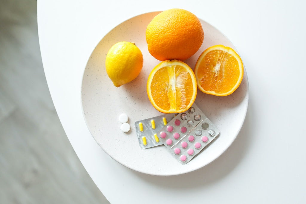 Closeup of oranges on plate with supplement pills