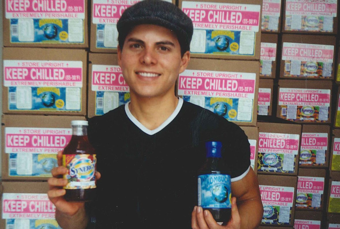 GT Dave holding original kombucha bottles and cases