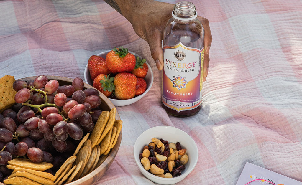 Man at picnic holding Lemon Berry SYNERGY Raw Kombucha