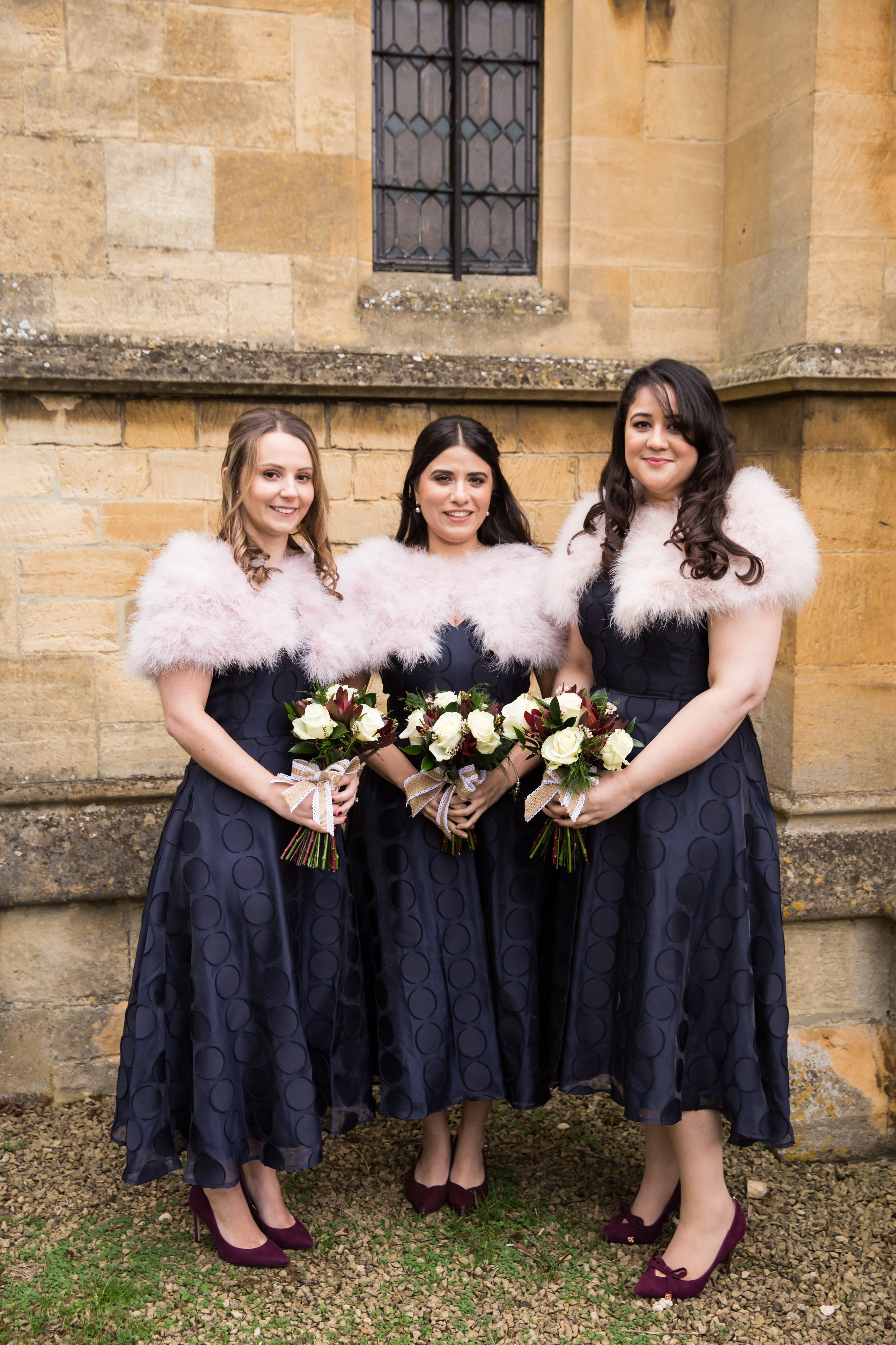 <p>Flowers- <a href="https://www.thebaytreeatcampden.com/">The Bay Tree at Campden</a> flowers (Chipping Campden) A bouquet of cream roses and deep red burgundy roses and green foliage, tied with a hessian and lace bow.</p> <p>Bridesmaids wore navy spot dresses from Coast paired with faux fur shrugs and burgundy court shoes</p>