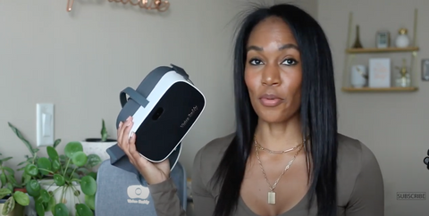 YouTuber Alisha Browne holding a white Vision Buddy Unit, talking to the camera.