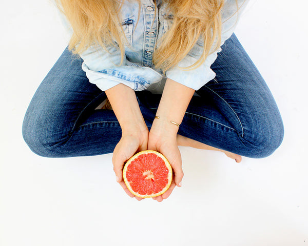 Holding a grapefruit cut in half