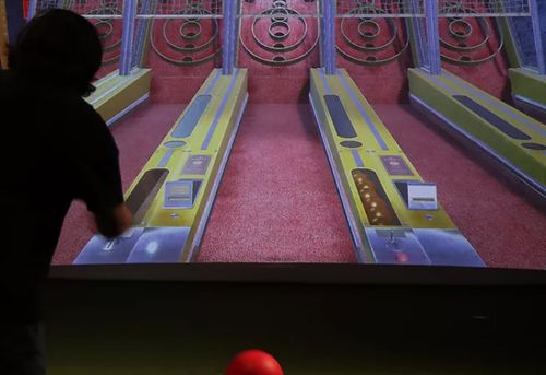 Person rolling skee-ball