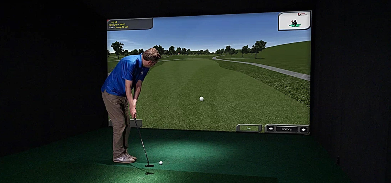 Man putting golf ball in Sports Coach simulator