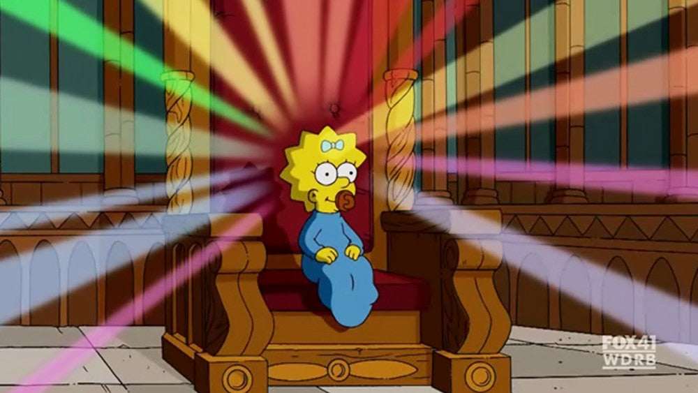 Maggie Simpson assise sur un trône avec une auréole multicolore tout autour de la tête.