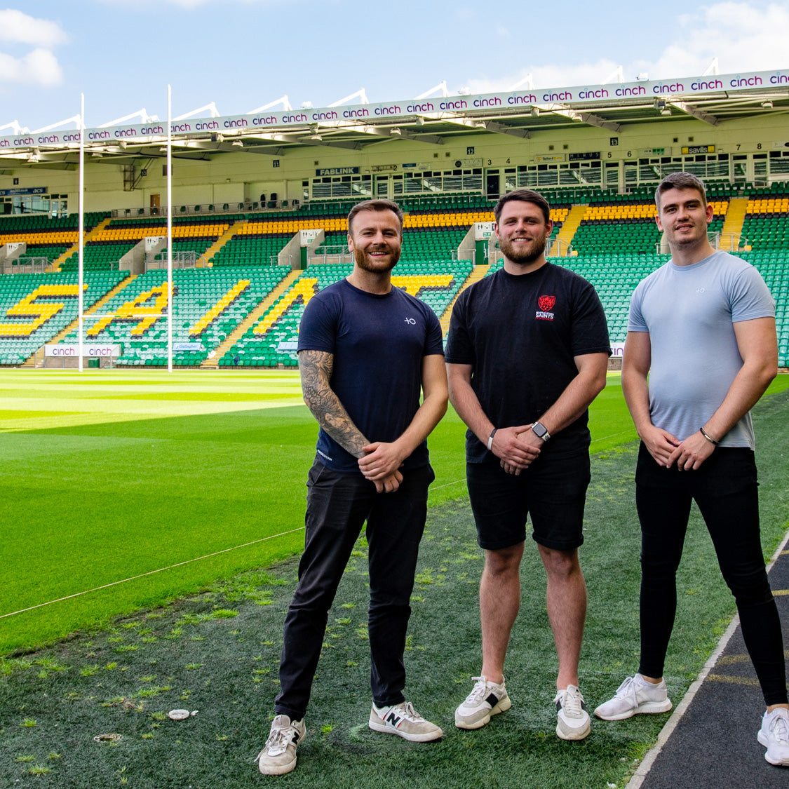 Three Men standing at a football pitch