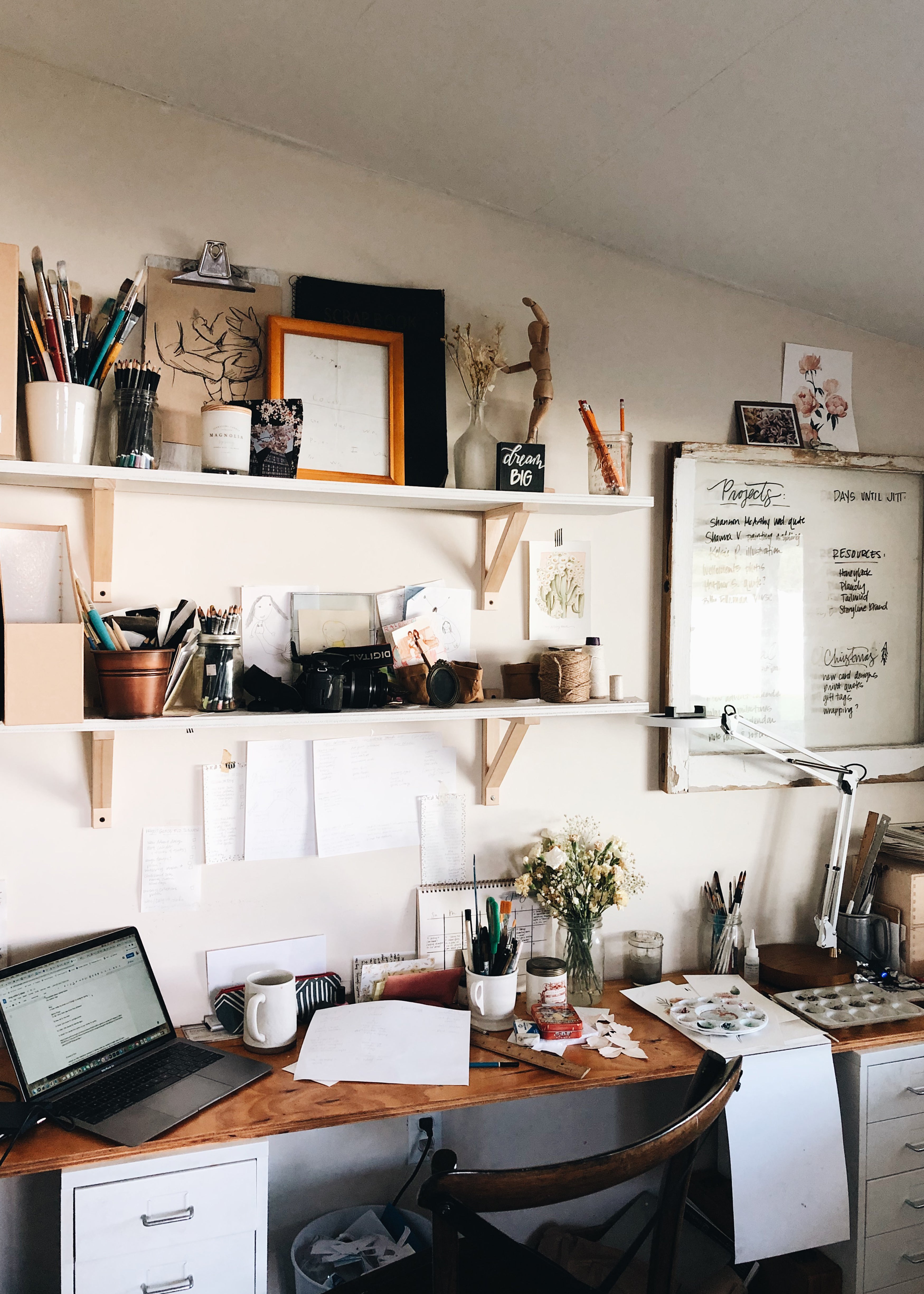 artist workspace with desk and shelves 
