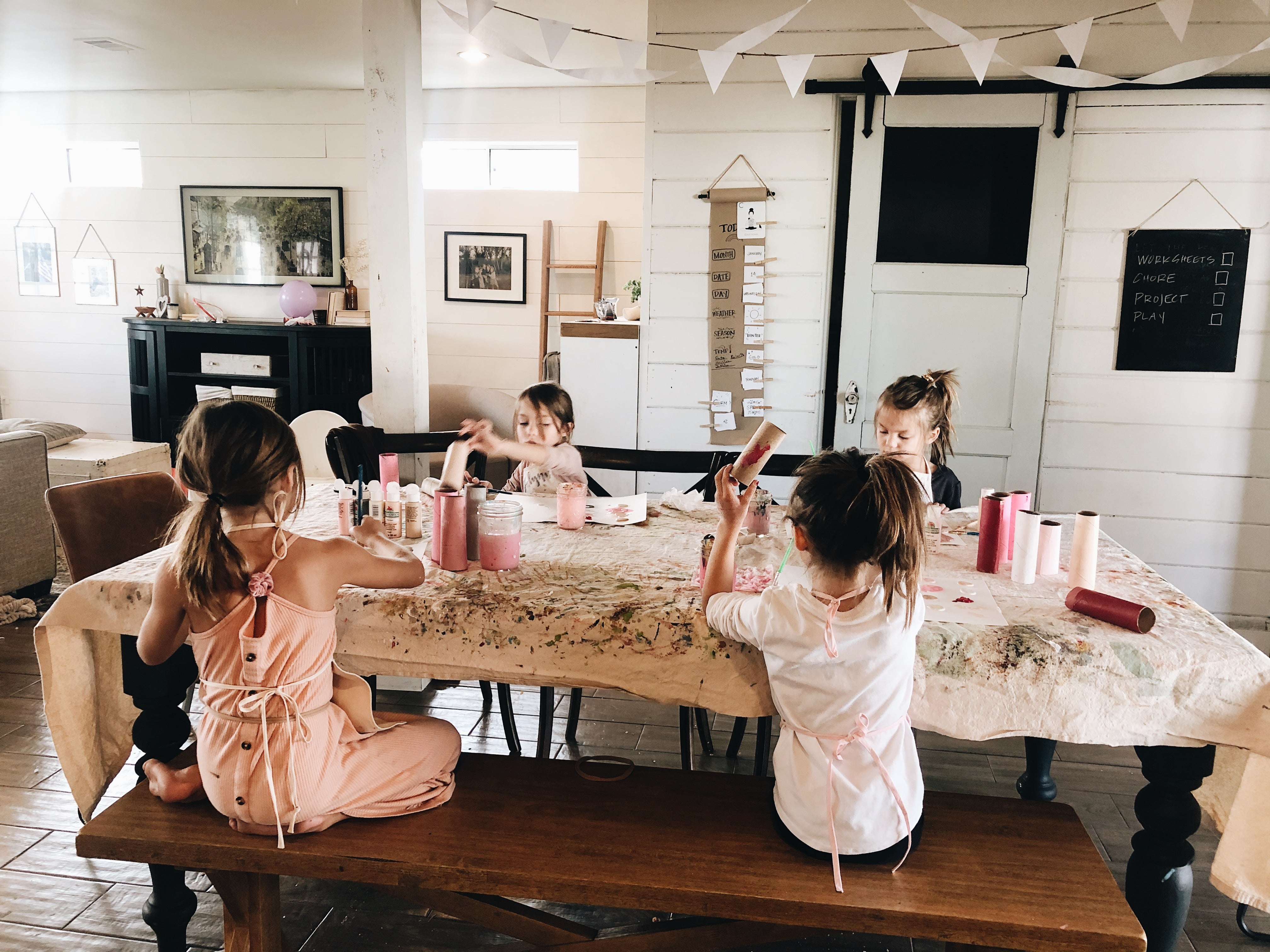 kids painting valentines crafts at their kitchen table