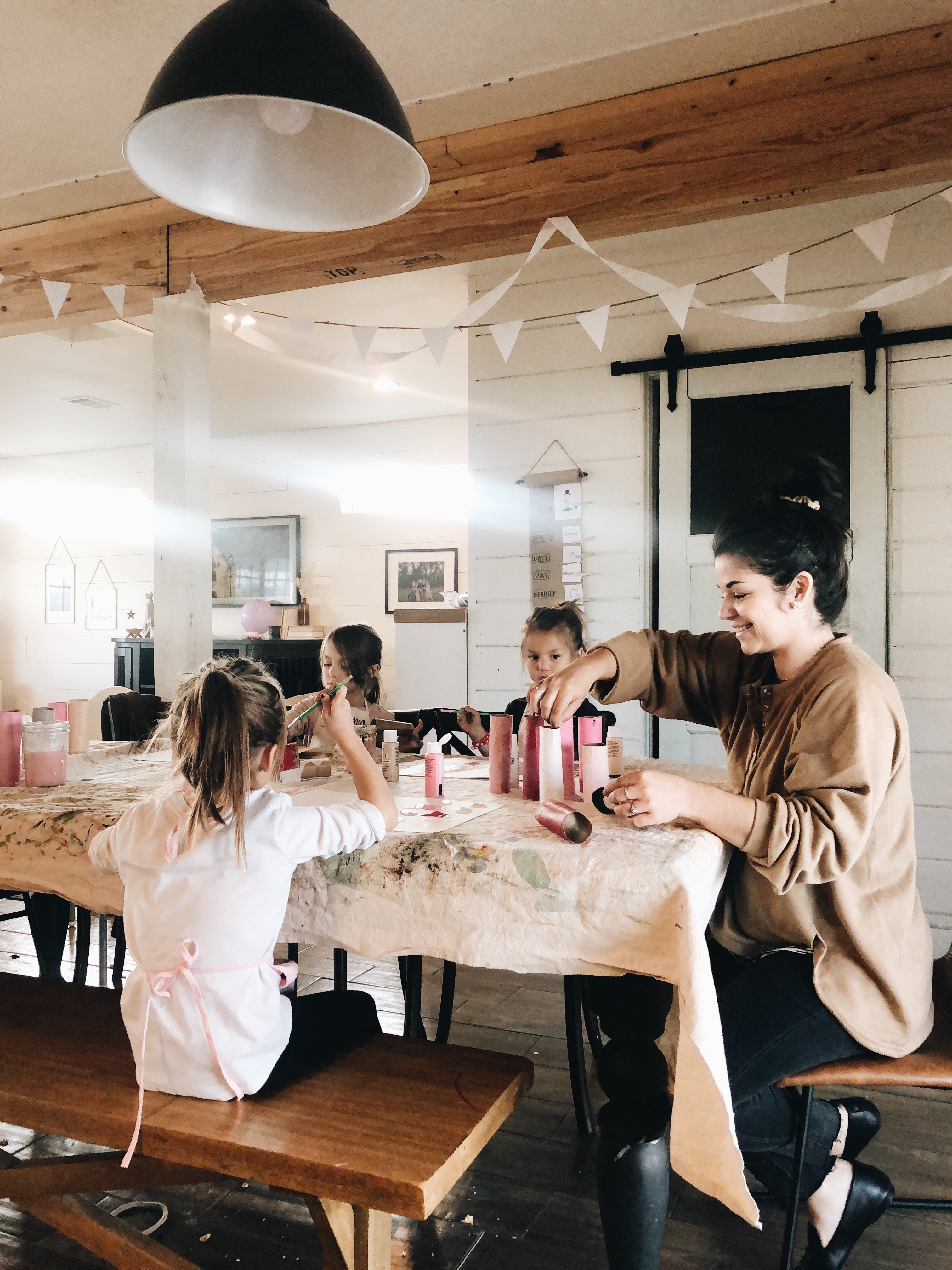 mom and kids painting DIY valentines crafts at home dining room table