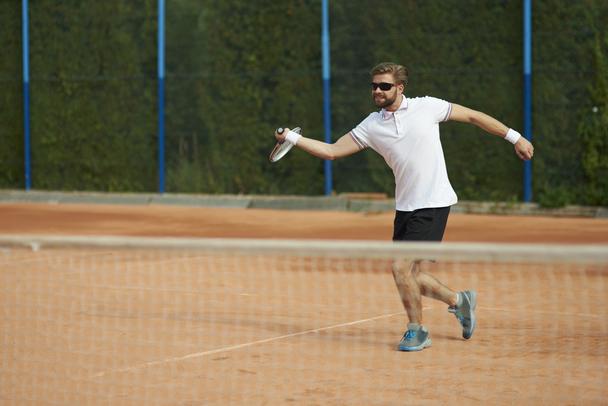 Man playing tennis under the sun - Solar bat