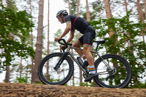 Man in Reilly cycling kit rides Reflex on forest path