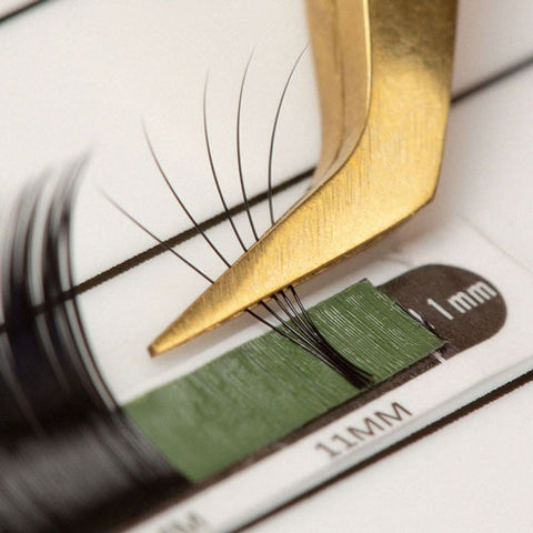 a close up photo of the boot of a pair of gold volume lash tweezers gripping a 5D fan | London Lash
