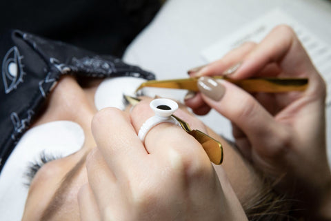 Lash Technician wearing a glue ring with eye lash glue