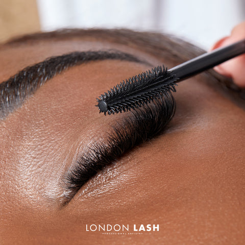 brushing lash extensions with mascara wand