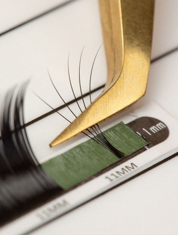 Close-up of lash tweezers picking up lash extensions