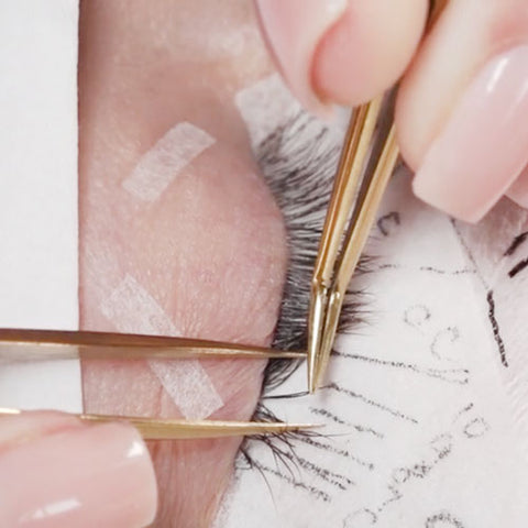 Eyelash tweezers placing eyelash extensions on individual lashes