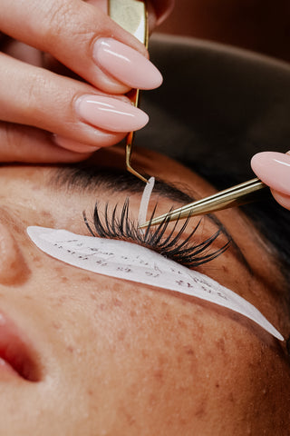 Lash Tech using eyelid tape to secure the eyelid for better access to natural lashes