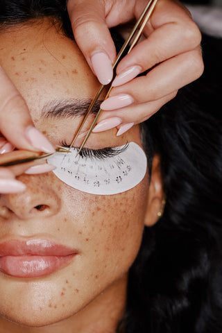 Applying Hybrid Lashes to individual lashes with eyelash tweezers and under eye patches