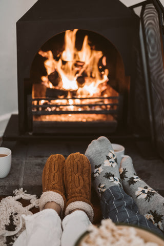 Cosy fireplace with burning logs and warm fluffy socks