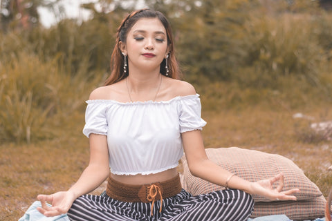 Young woman meditating and using calming techniques. Self-care and stress avoidance