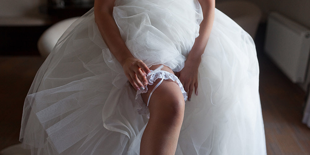 Bride putting on a garter on her wedding day