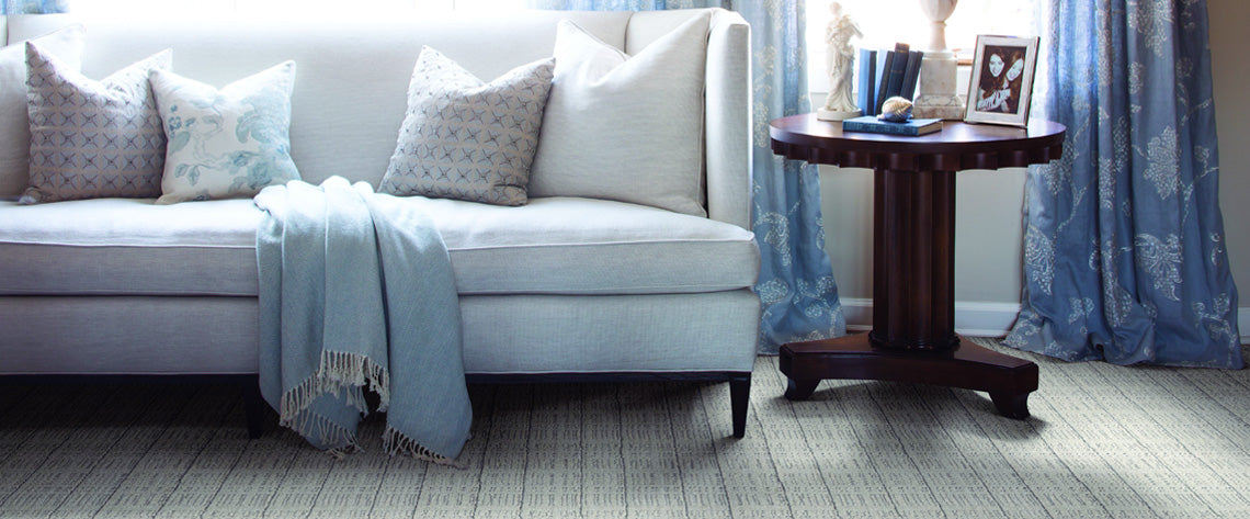 tan broadloom carpeting with blue couch