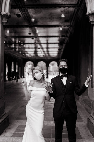 Image shows couple enjoying their wedding during coronavirus wearing masks