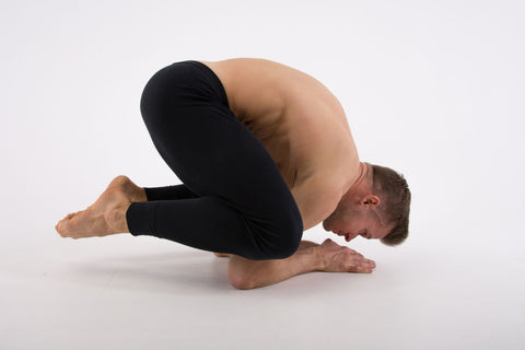 Man doing a baby crow pose