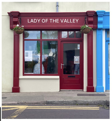 The outside of our shop, painted maroon, with LADY OF THE VALLEY signage in cream.