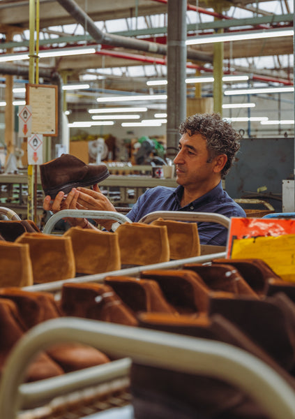 Han Ates looking at Shoes inside Sanders Factory