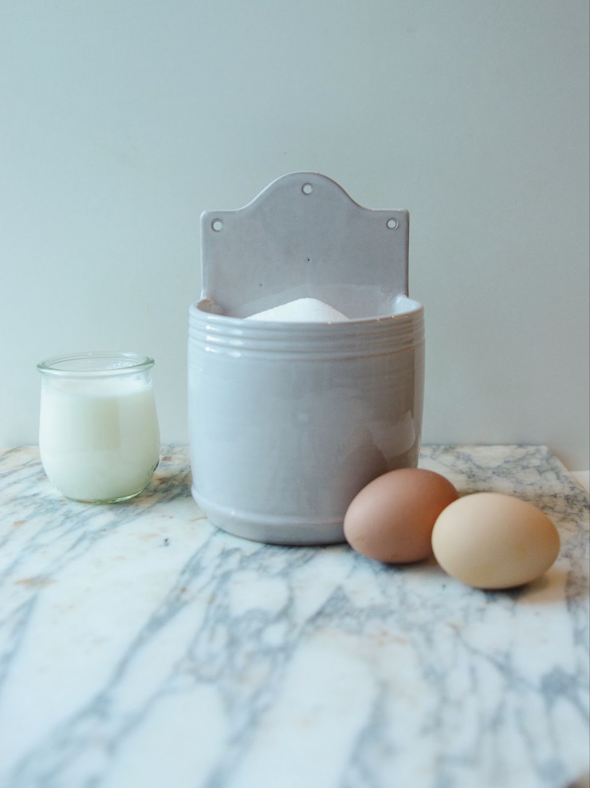 Salt cellar with holes for hanging on wall.