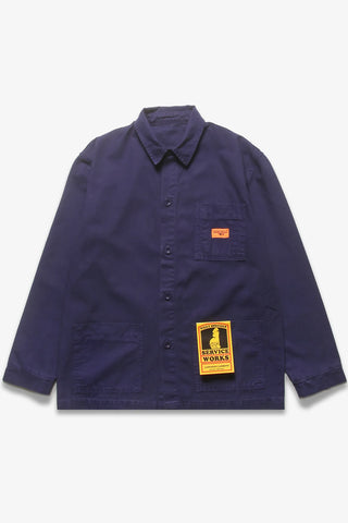 Dark blue work jacket sits on white background. It has an orange tag on the breast pocket and a yellow tag coming out of the pocket.