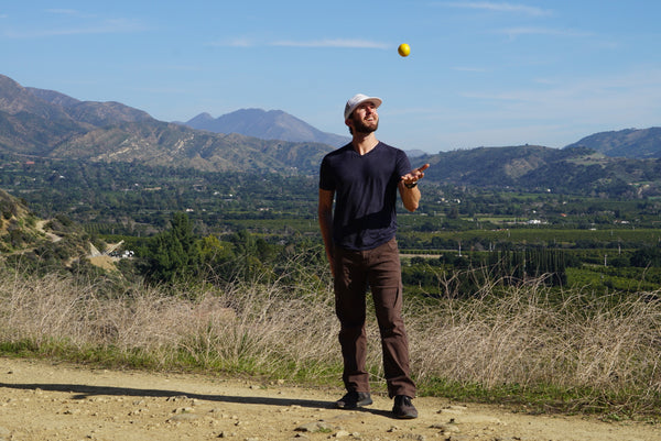 Stephen tossing a ball in front of a mountain landscape