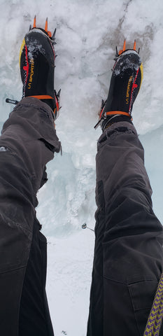 Ice climbing boots with spikes on an ice climb