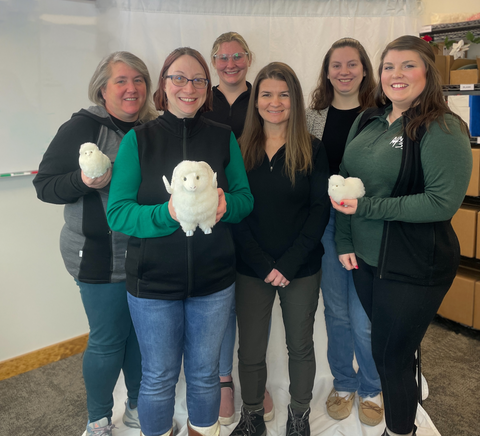 the women of Minus33, standing in a group and smiling