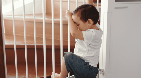 child trying to climb over baby gate